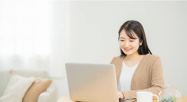 パソコンを使って企業情報を閲覧する女性